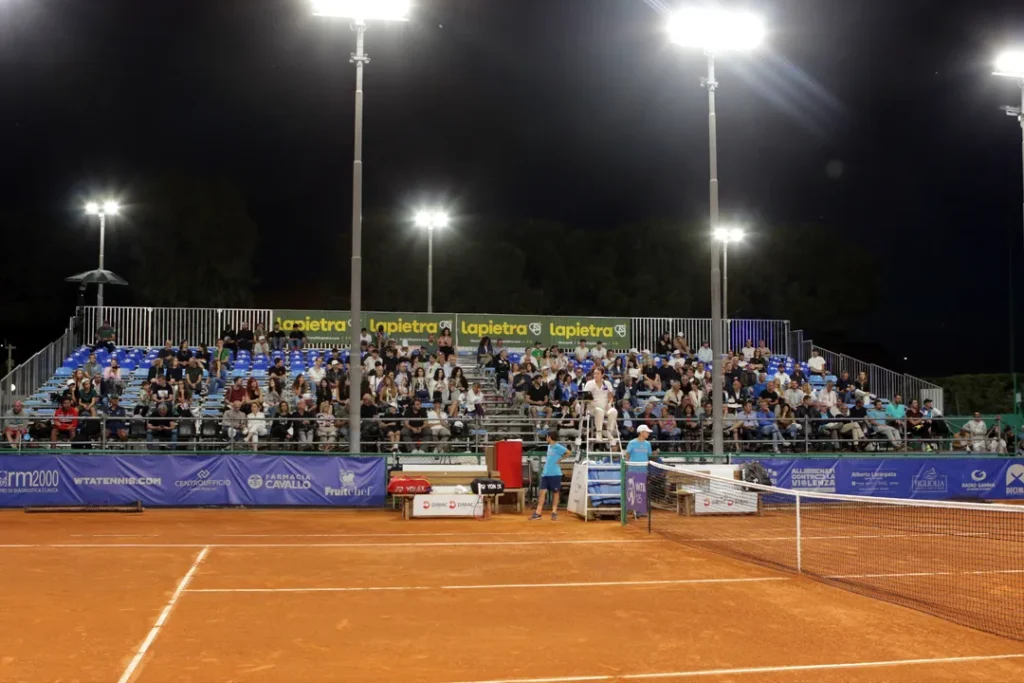 Match serale dell’Open delle Puglie con tribune illuminate e pubblico presente.
